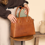 Styled Fit Perspective of Marsala Full-Grain Leather Handbag 女士 on Model - Natural Daylight Drape